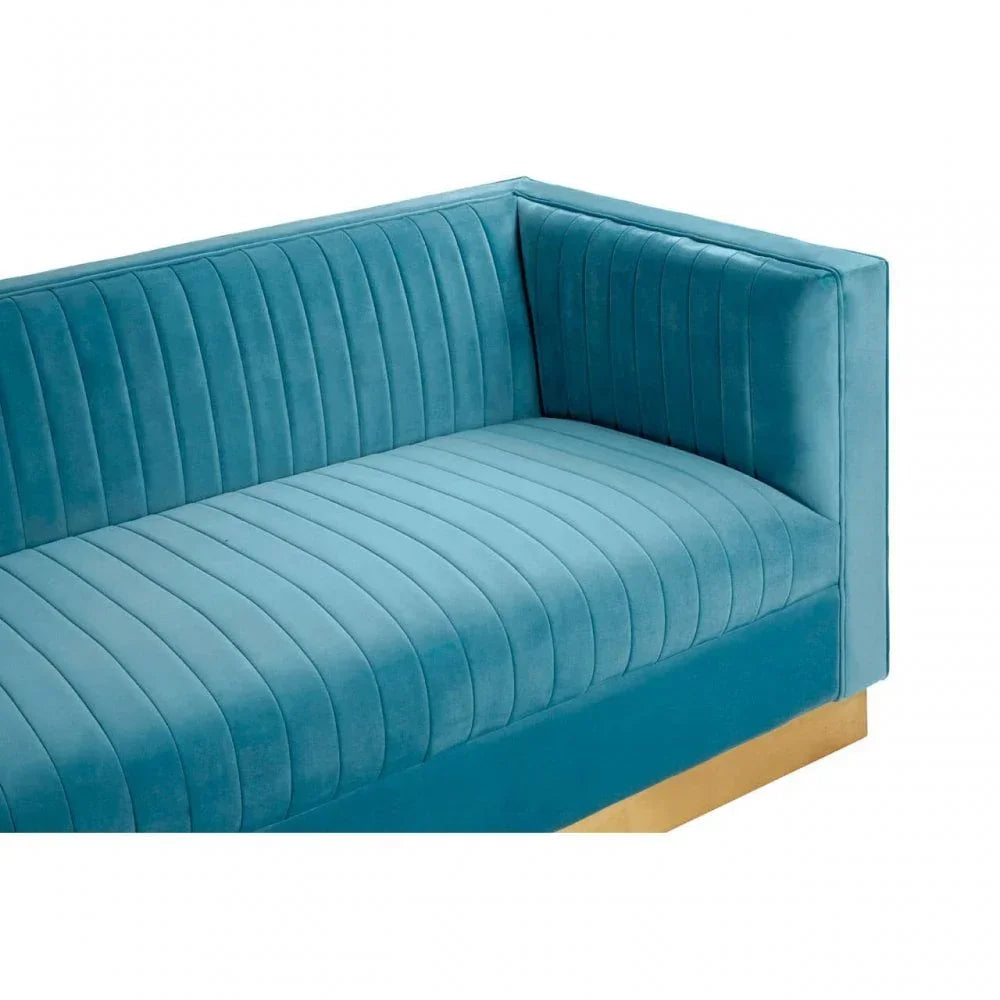 Blue velvet sofa with vertical channel tufting and gold base, corner angle view