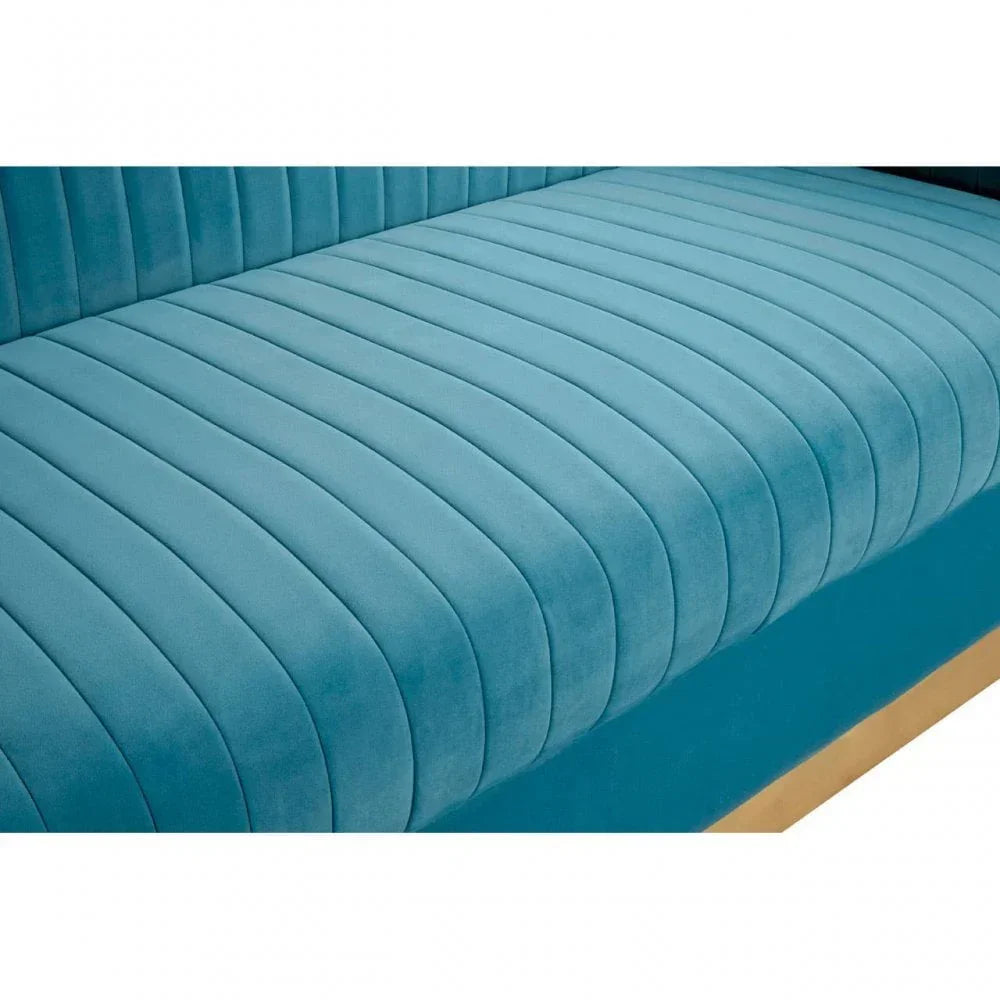 Closeup of blue velvet sofa seat with vertical stitched detail and gold base