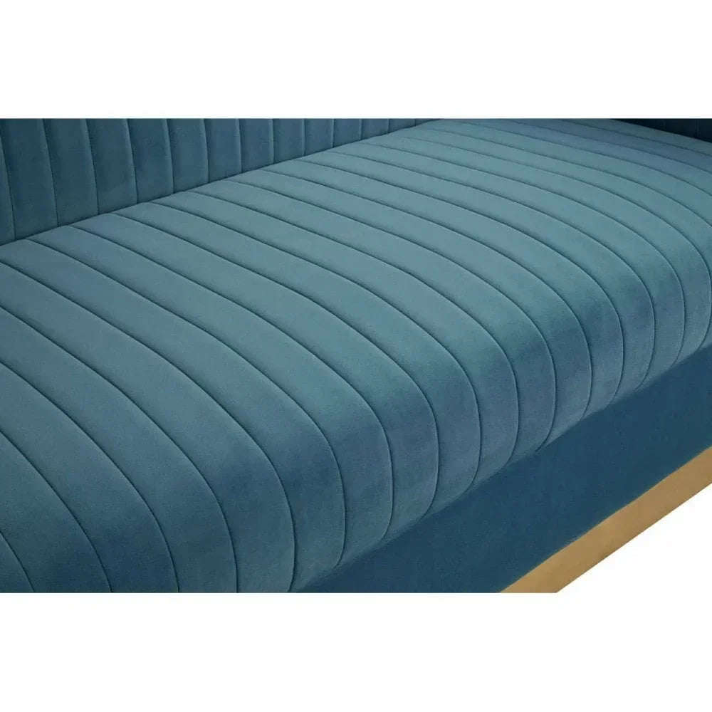 Blue velvet sofa seat with vertical stitched upholstery and wooden base detail closeup