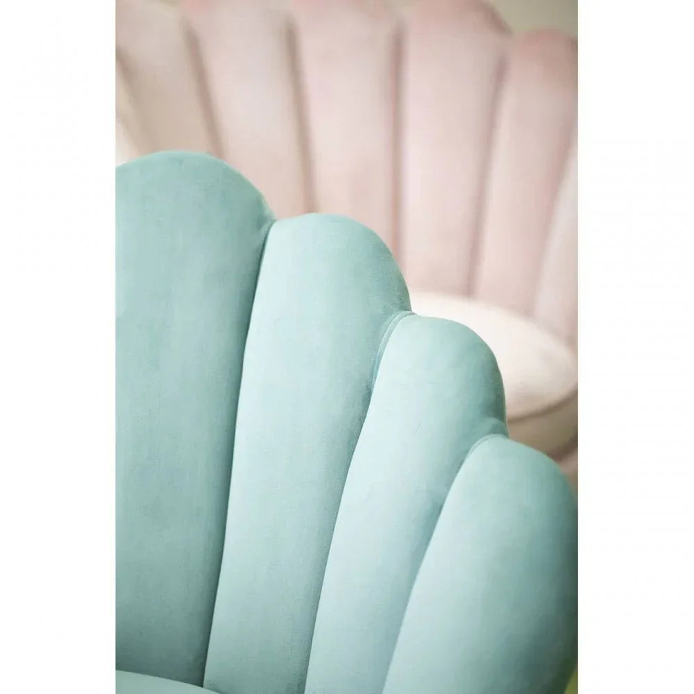 Blue scalloped velvet accent chair with pink chair in background