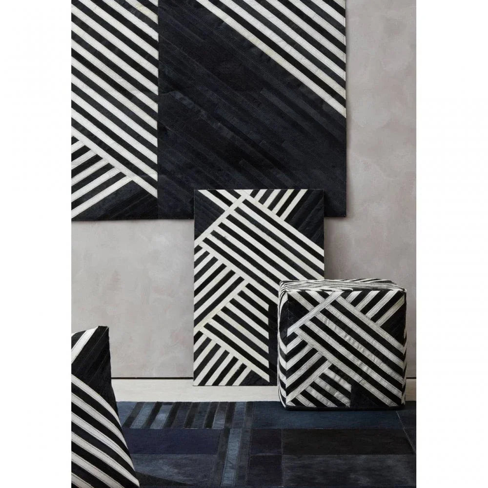 Black and white geometric ottoman with matching patterned wall panels and rug