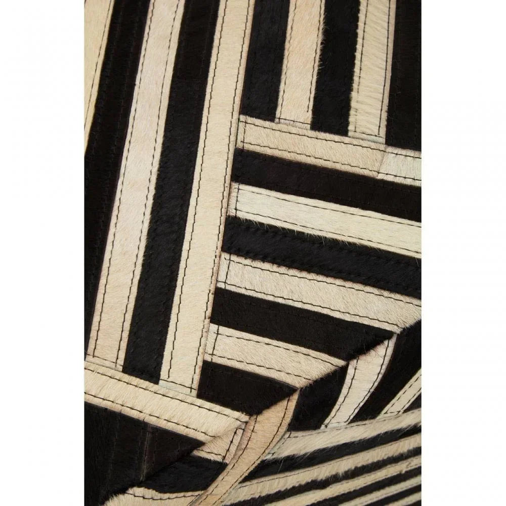 Closeup of black and cream geometric pattern rug with stitched hide strips
