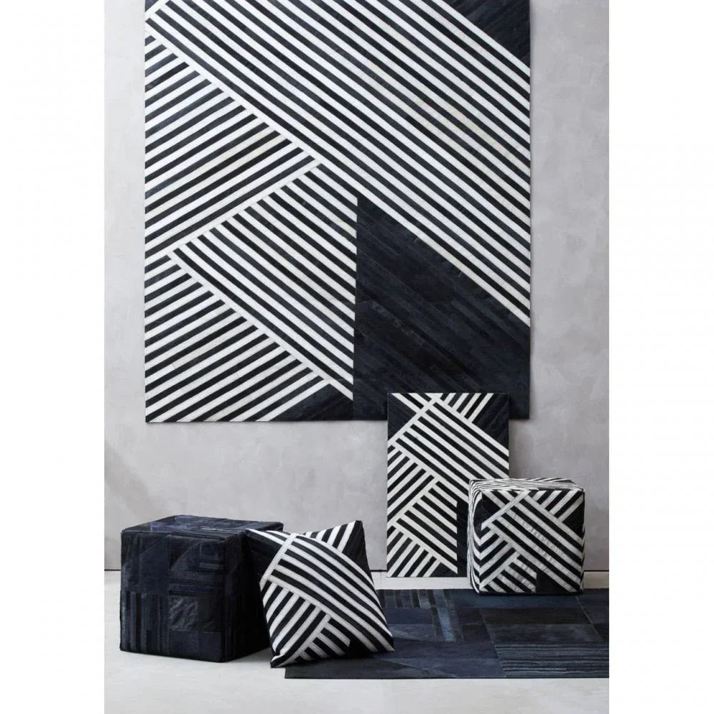 Black and white geometric rug, pouffes, and cushions with diagonal stripe patterns