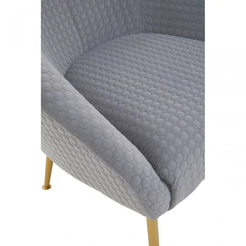 Grey textured fabric armchair with gold metal legs, close side angle view