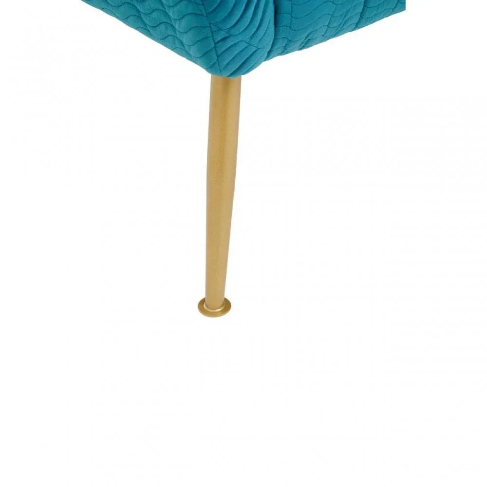 Close up of gold chair leg with teal quilted fabric upholstery detail
