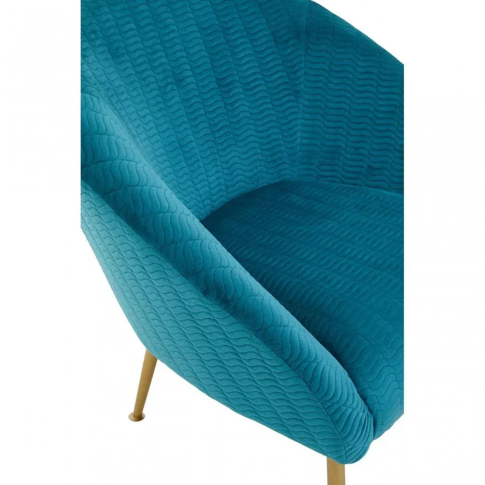 Close view of teal accent chair with quilted velvet upholstery and gold metal legs