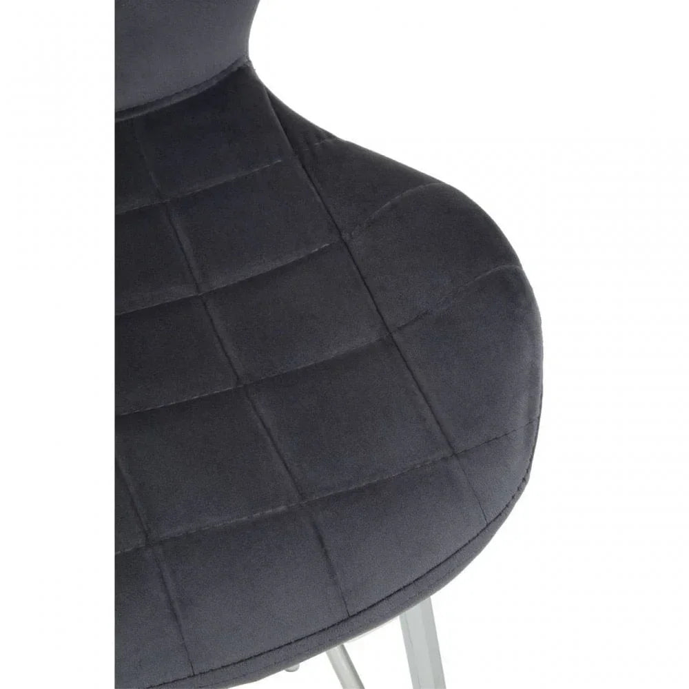 Closeup of dark grey velvet dining chair seat with grid stitching and chrome legs
