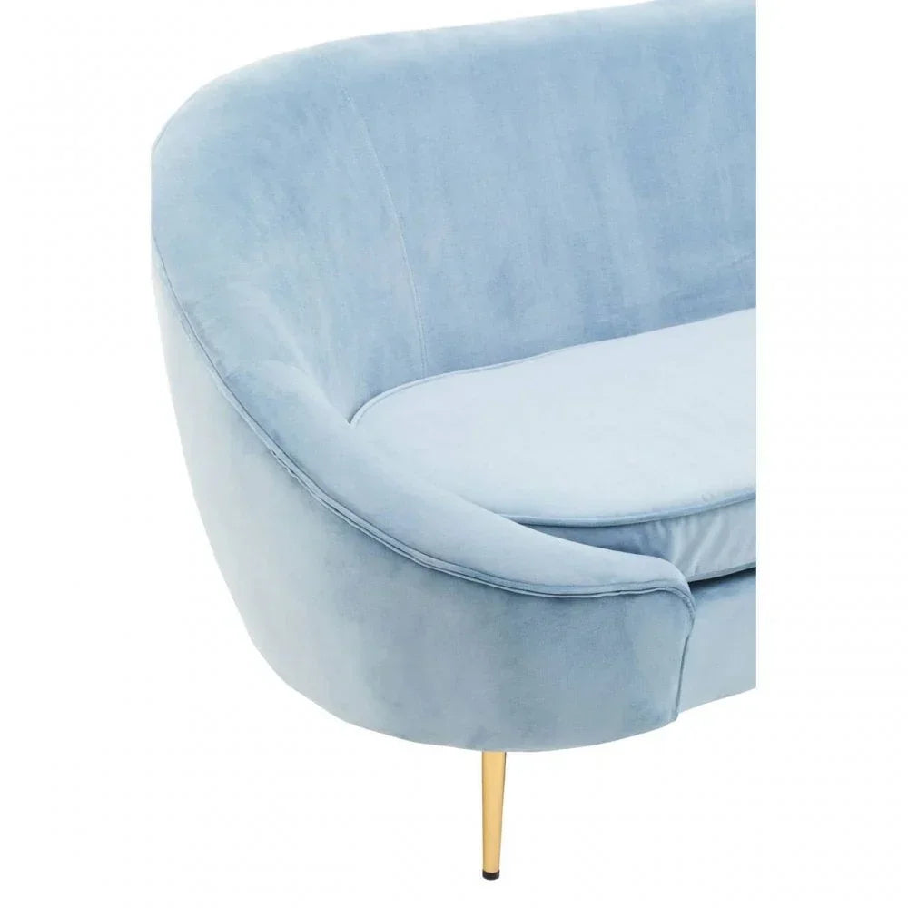 Close view of blue velvet sofa arm with curved backrest and gold metal leg