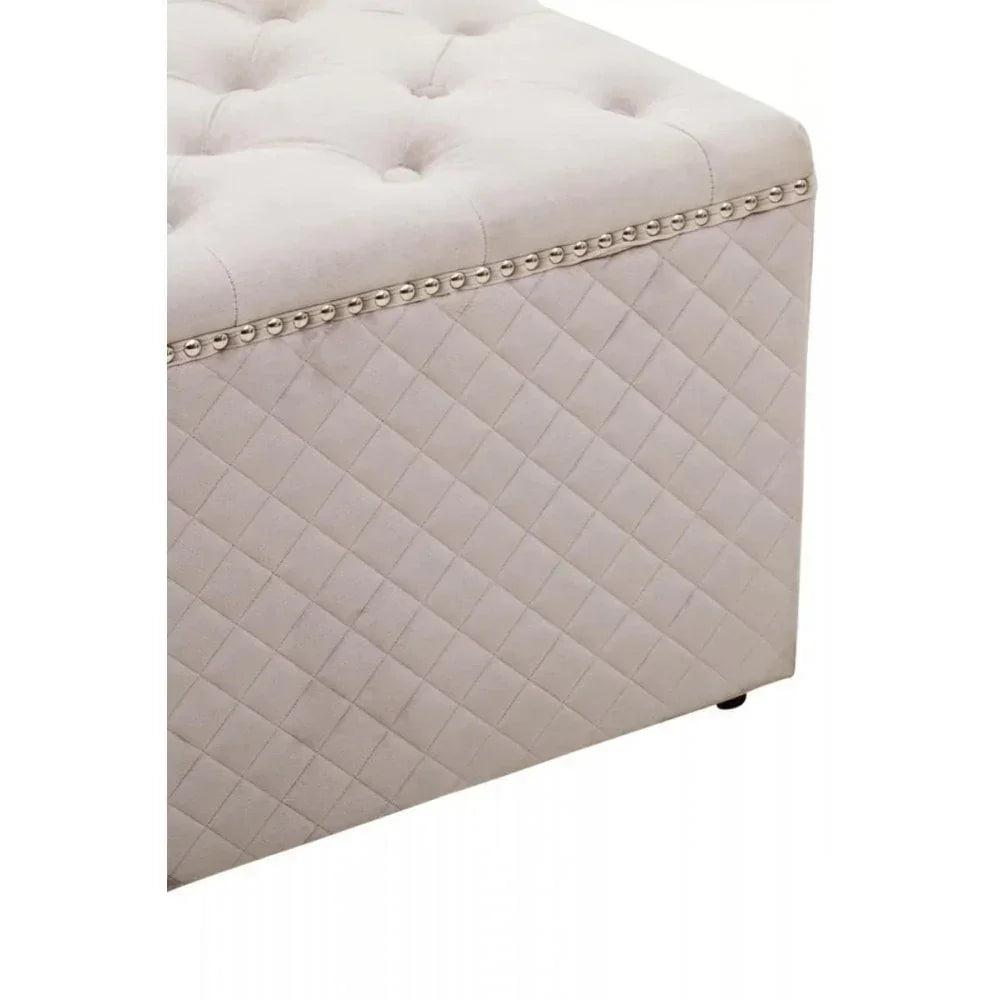 Beige upholstered ottoman with diamond quilted sides and decorative stud trim