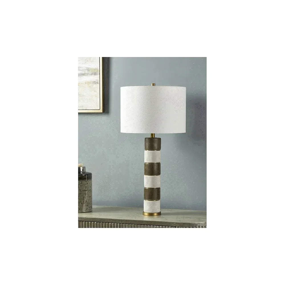 Striped ceramic table lamp with white drum shade on modern console against grey wall