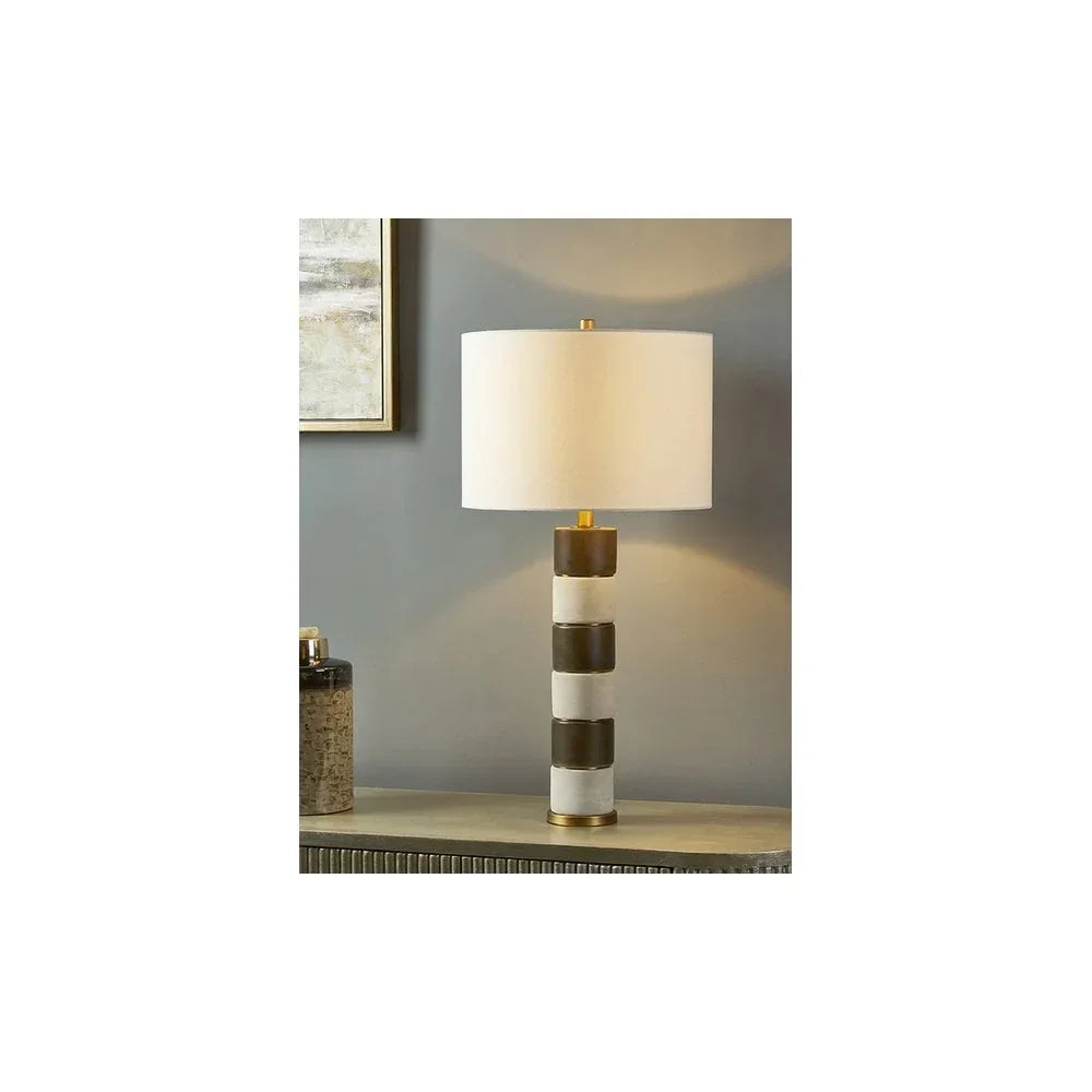 Modern table lamp with white shade and striped gold and marble base on console table
