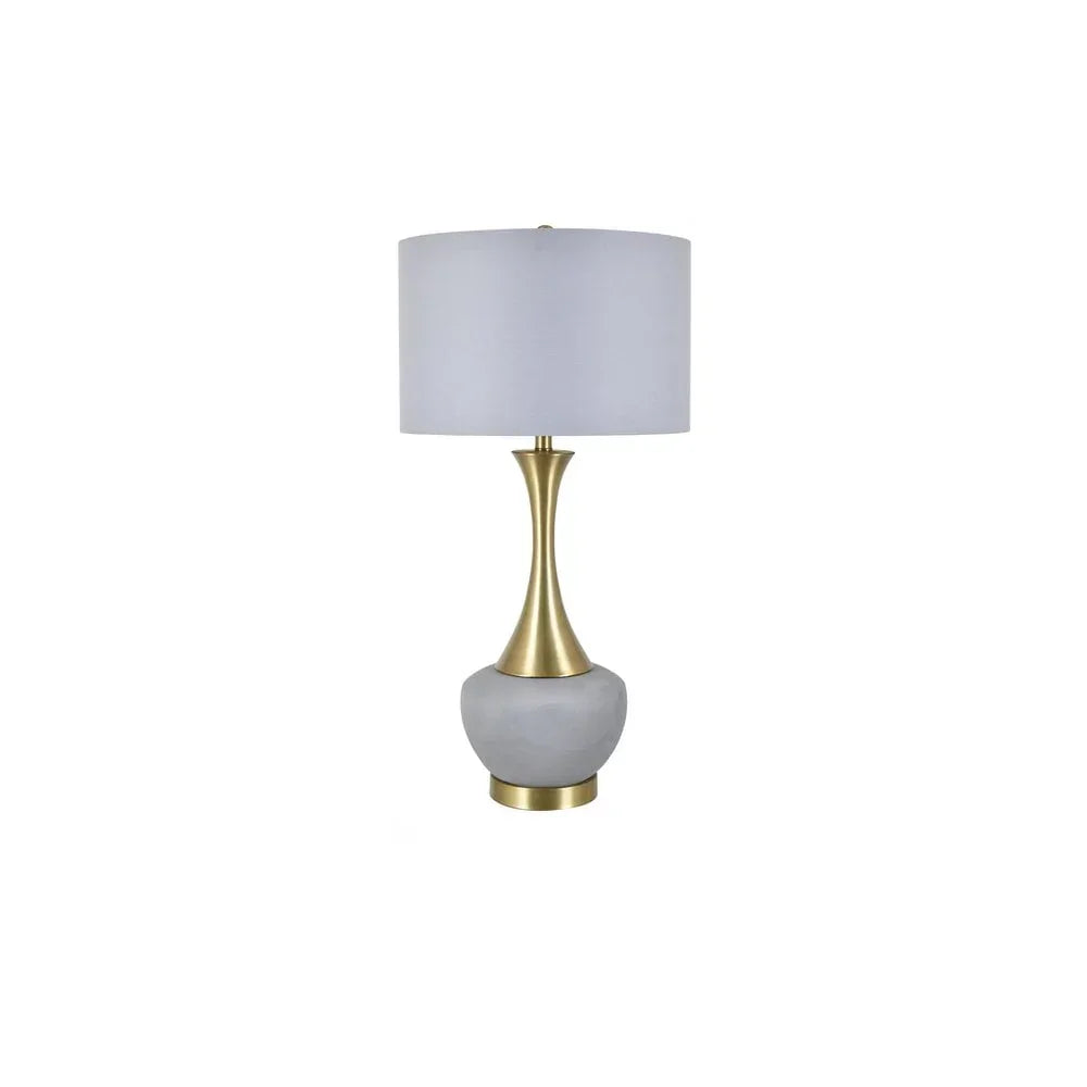 Gold and marble table lamp with white drum shade on white background