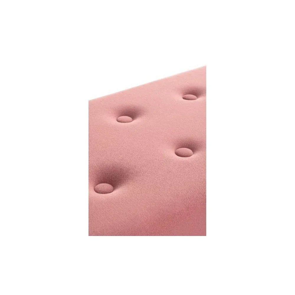 Closeup of pink velvet upholstered sofa seat cushion with button tufting
