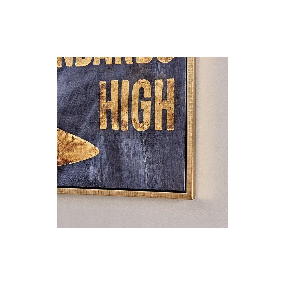Gold text wall art with wood frame on beige wall, partial motivational sign visible