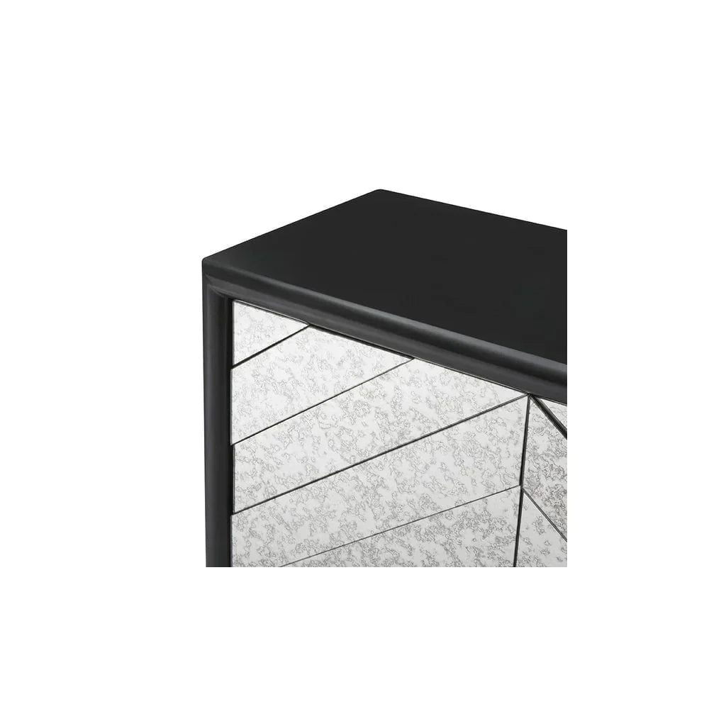 Corner closeup of mirrored chest of drawers with black frame and patterned glass panels