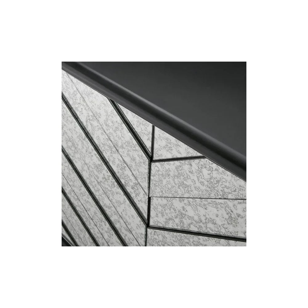 Closeup of chevron mirrored chest of drawers with black trim and textured glass finish