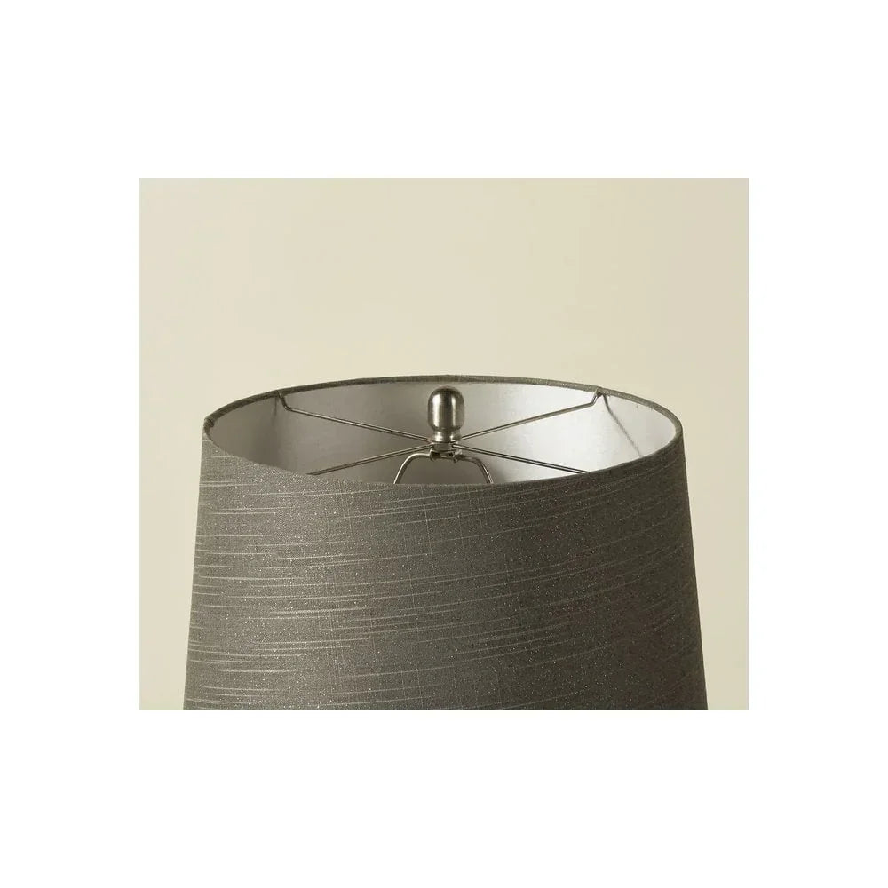 Close view of grey fabric lampshade with metallic frame and finial