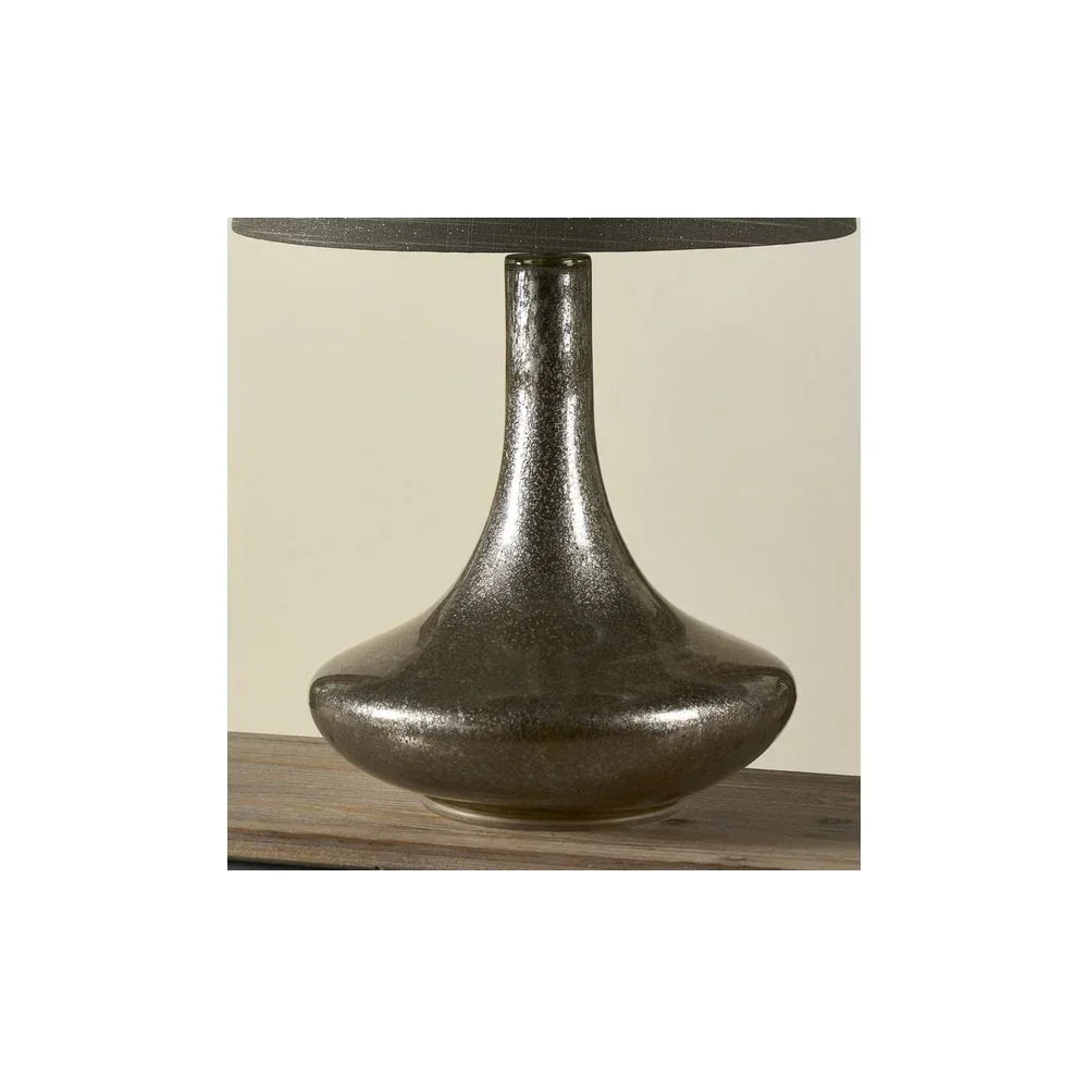 Black glass table lamp base with glossy finish on wooden surface