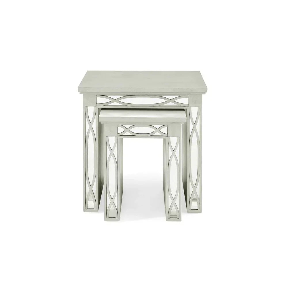 Grey wooden nesting tables with decorative side panels, stacked front view