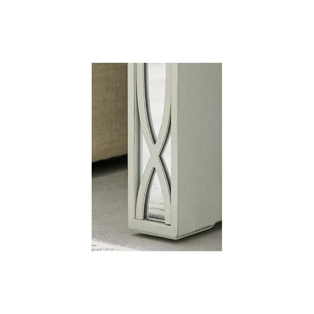Close-up of a painted wood table leg with decorative glass panel and crossed pattern detail