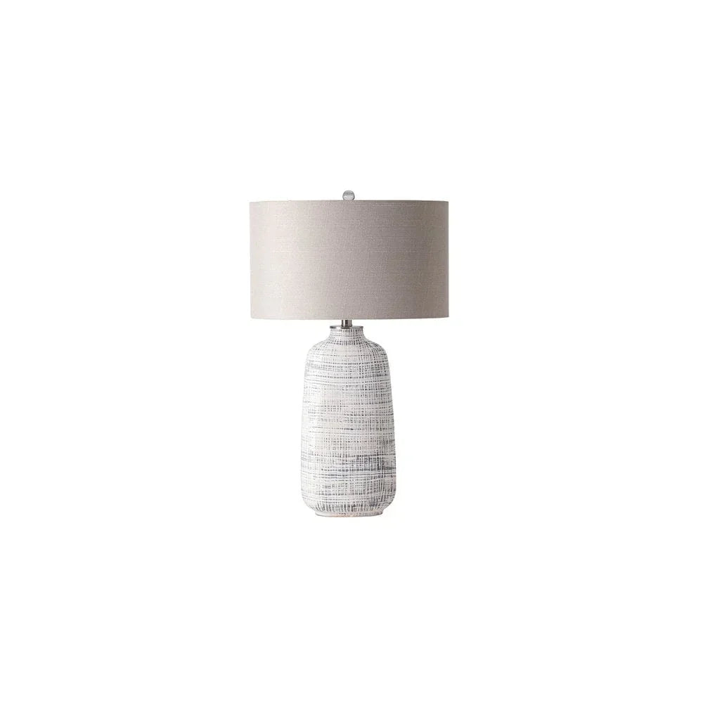 Textured ceramic table lamp with light grey fabric shade on white background
