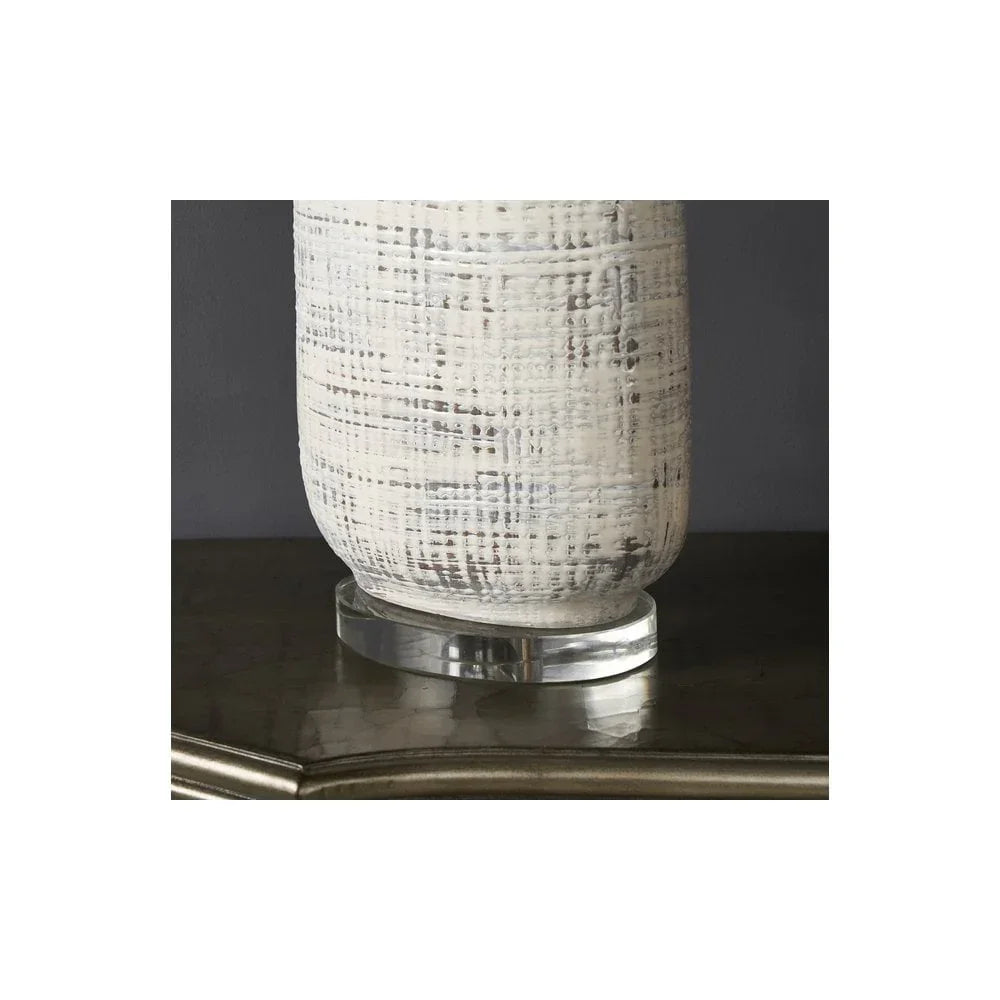 Textured white ceramic vase with clear base on marble console table
