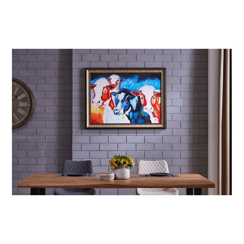 Modern dining table with upholstered chairs, sunflower centerpiece, and framed cow wall art