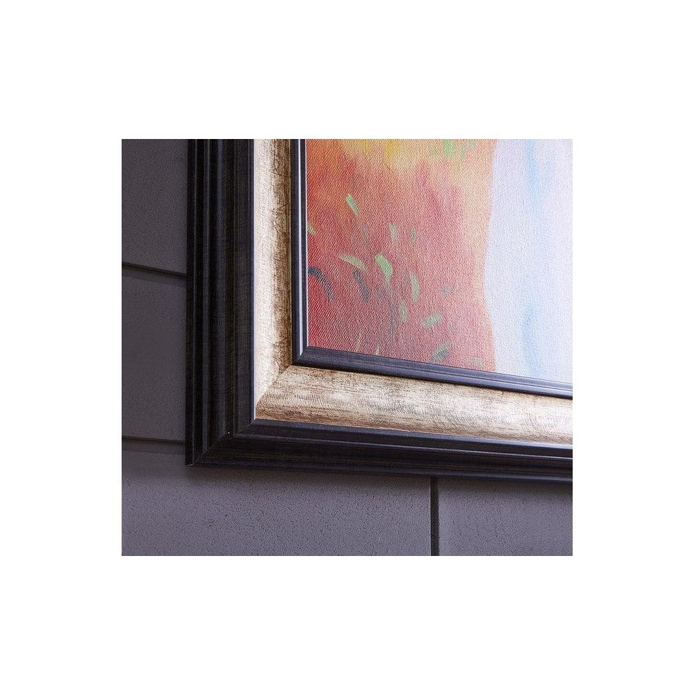 Close-up of framed wall art with black and gold trim on grey tiled wall
