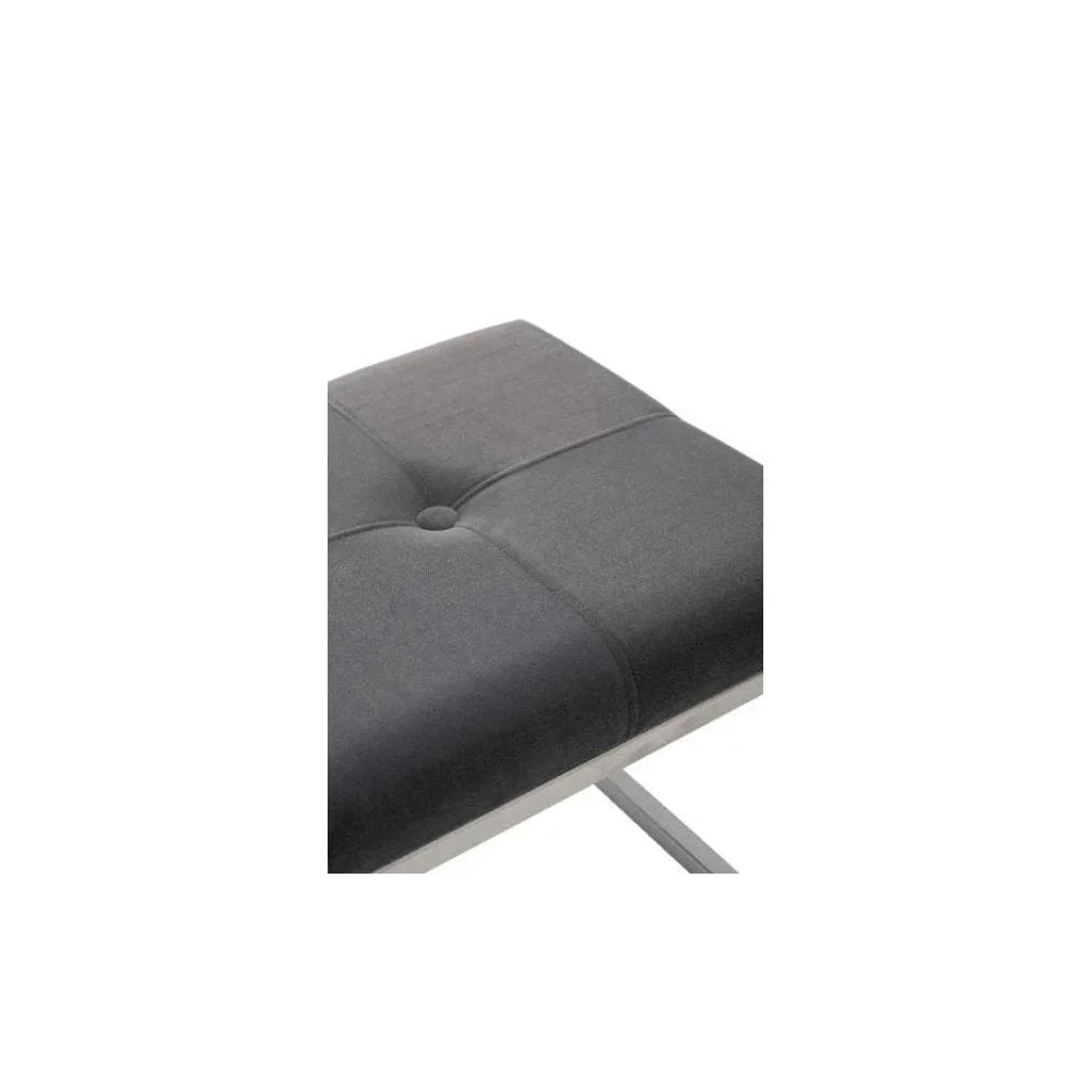 Grey upholstered stool with button-tufted seat and chrome legs, close-up view