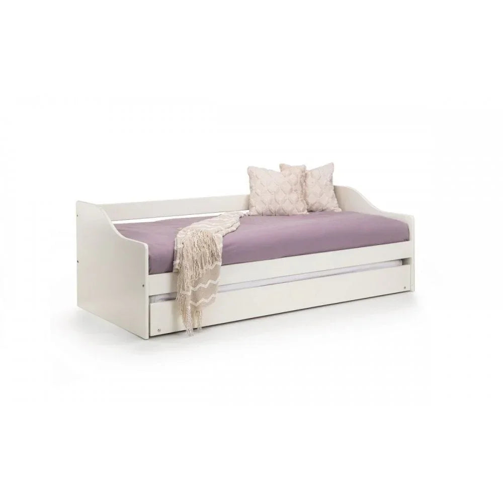 White day bed with lavender mattress, two cream cushions, and a pull-out trundle drawer