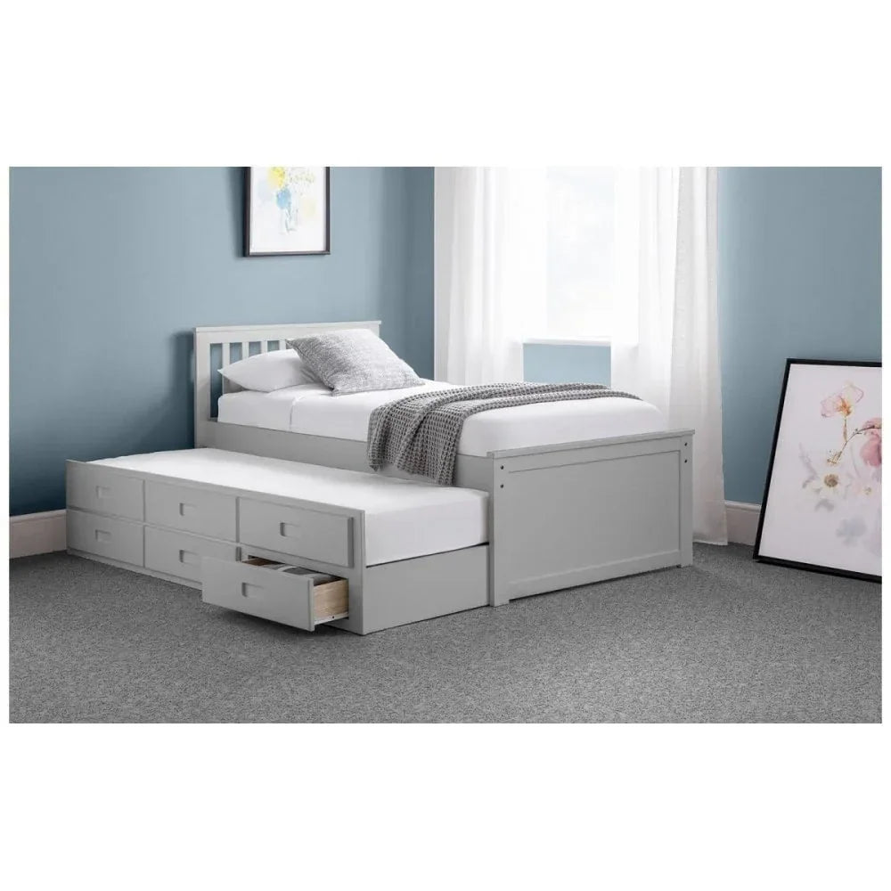 Grey wooden trundle bed with storage drawers in a modern bedroom with blue walls