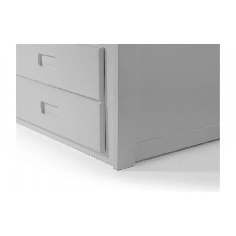 Closeup of white wooden chest of drawers with integrated handles and smooth finish