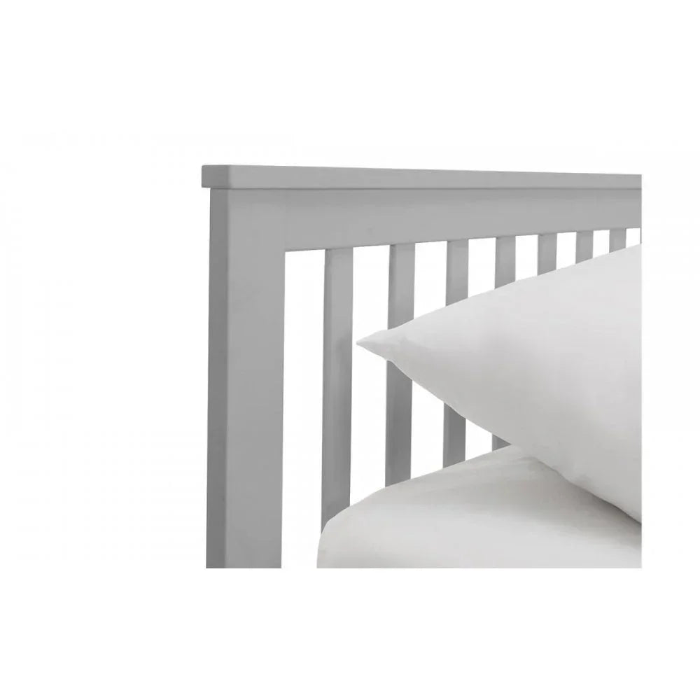 White wooden bed frame with slatted headboard and pillow close-up
