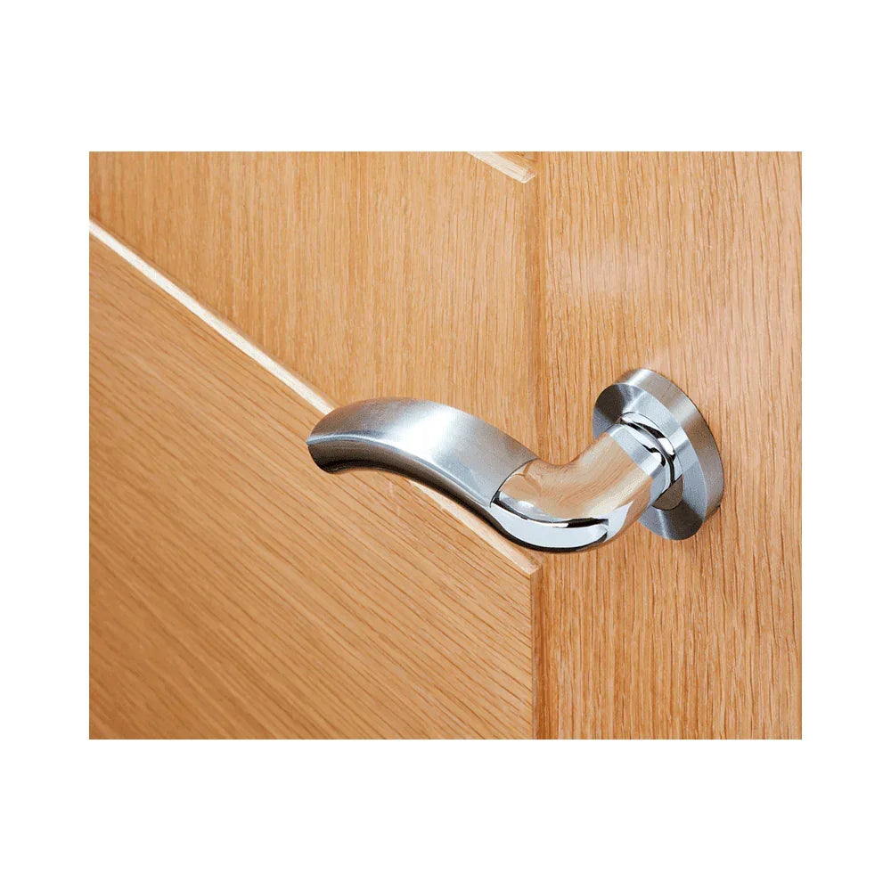 Satin chrome door handle on light wood interior door, close-up of lever design