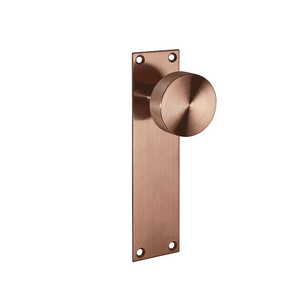 Copper door handle with round knob and rectangular backplate, wall-mounted design