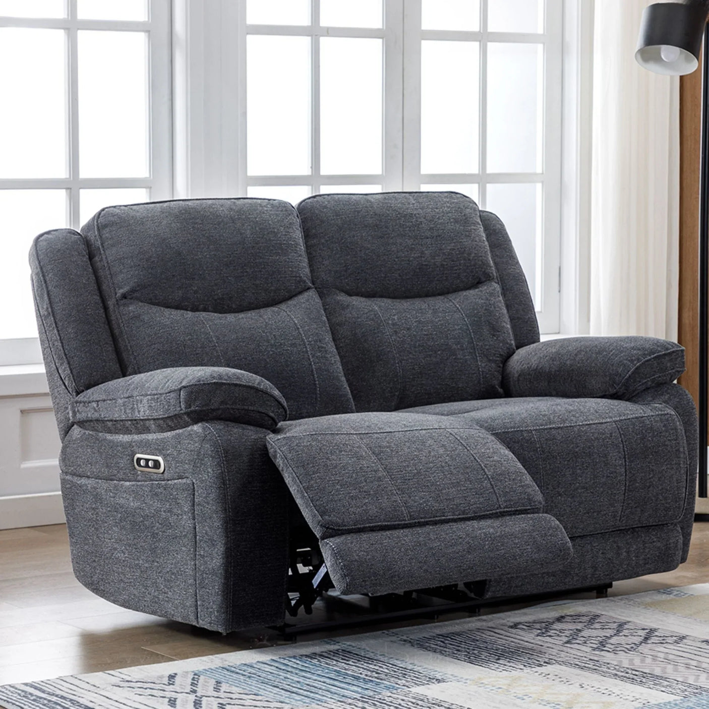 Dark grey electric recliner sofa for two with fabric upholstery in living room setting