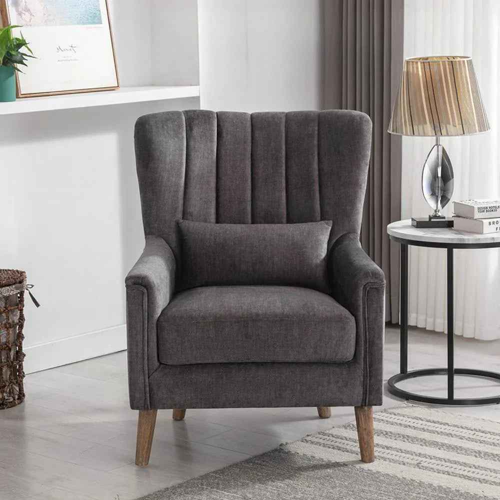 Graphite fabric armchair with wooden legs in living room beside round side table and lamp