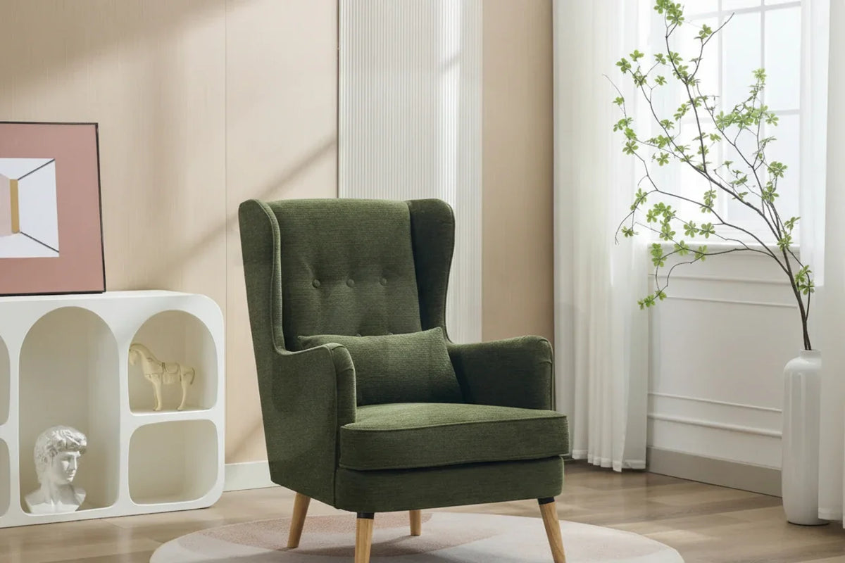 Moss green wing chair with cushion and wooden legs in a modern living room setting