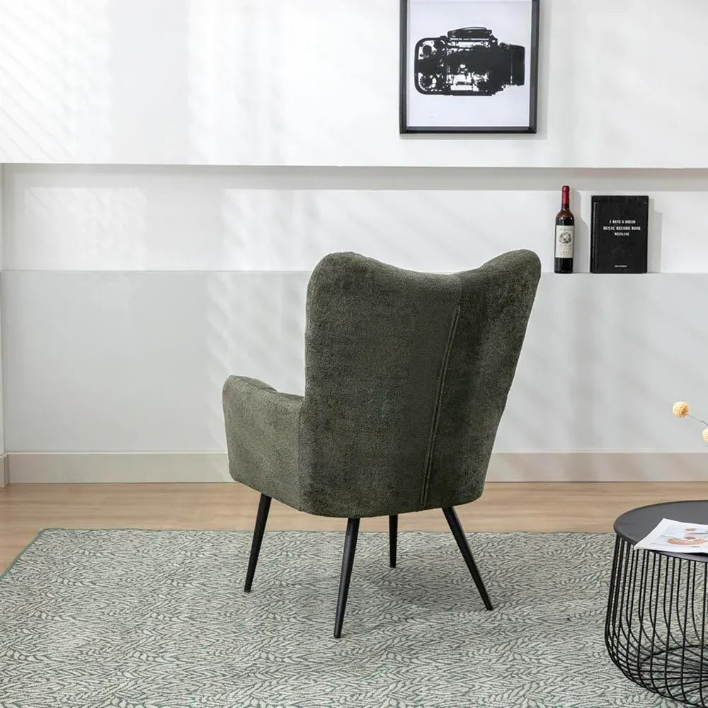 Green accent chair with fabric upholstery and black metal legs on patterned rug