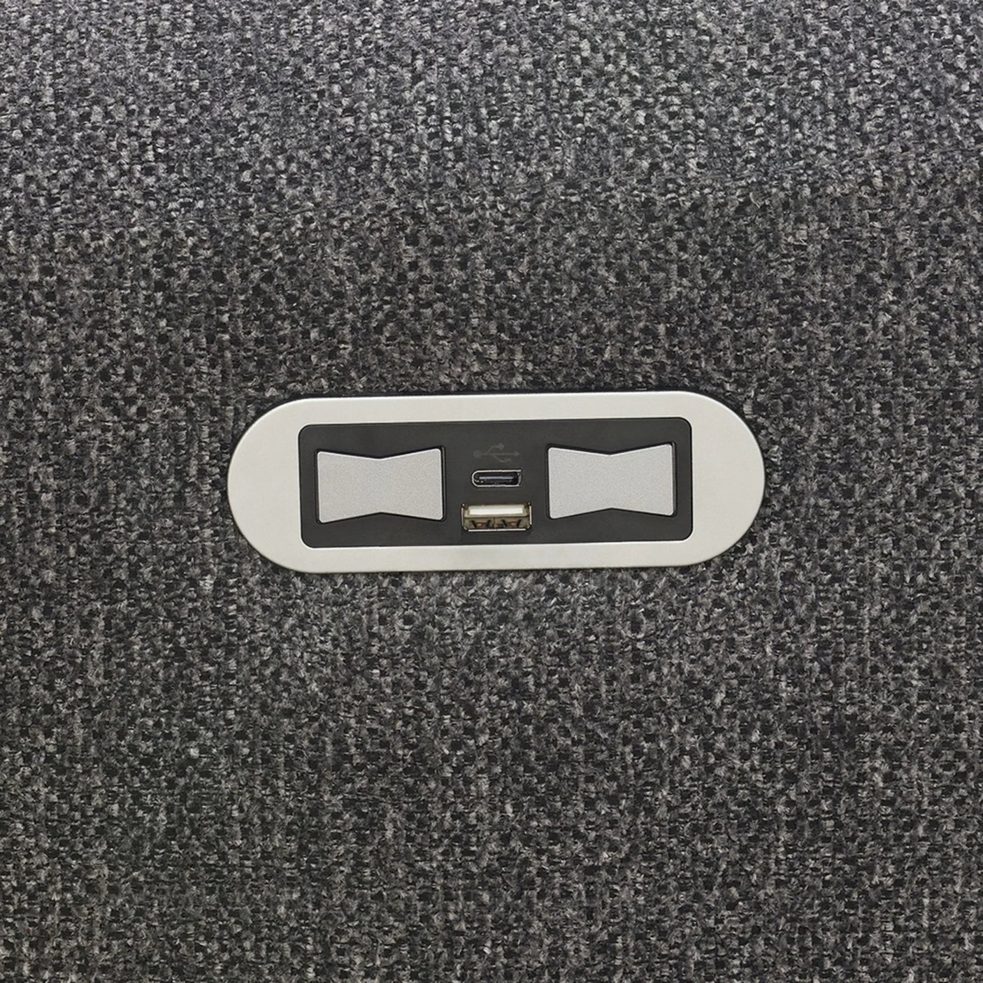 Close-up of USB charging ports set in dark grey fabric upholstery