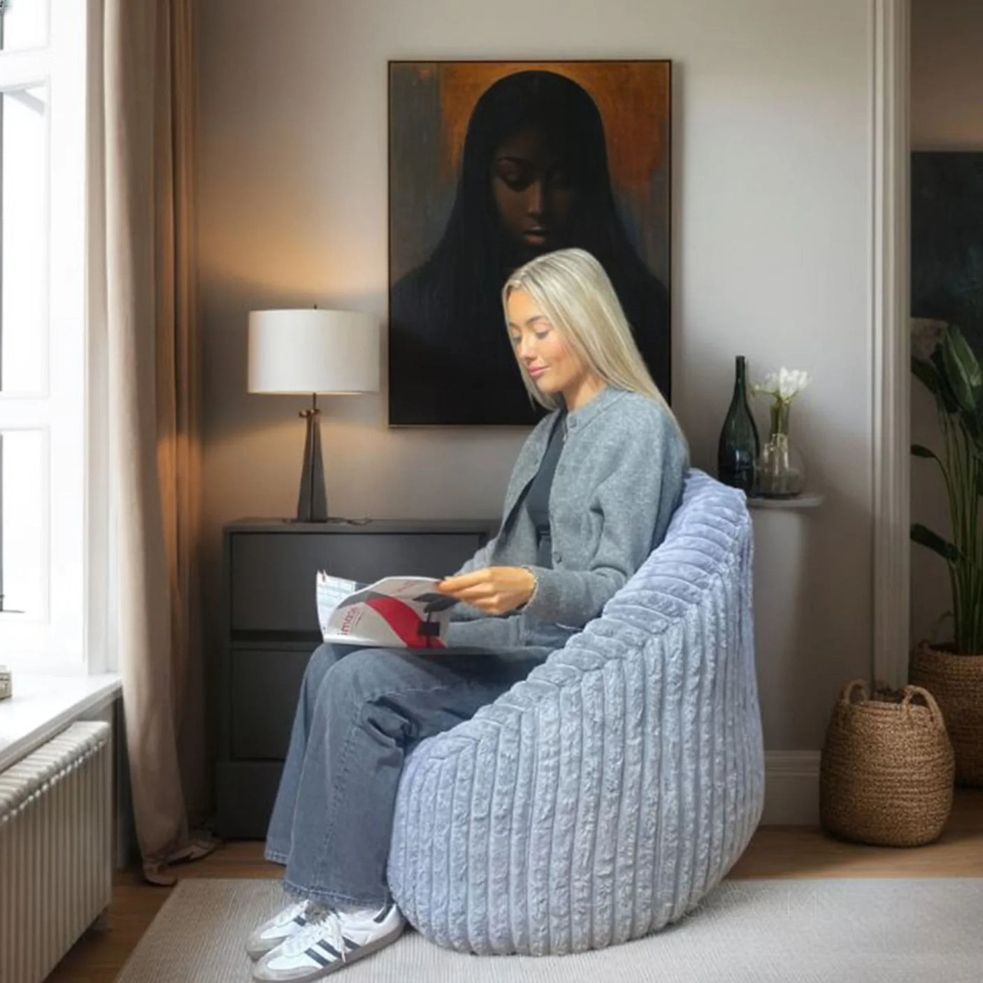 Grey cord bean bag chair in living room with person reading by window
