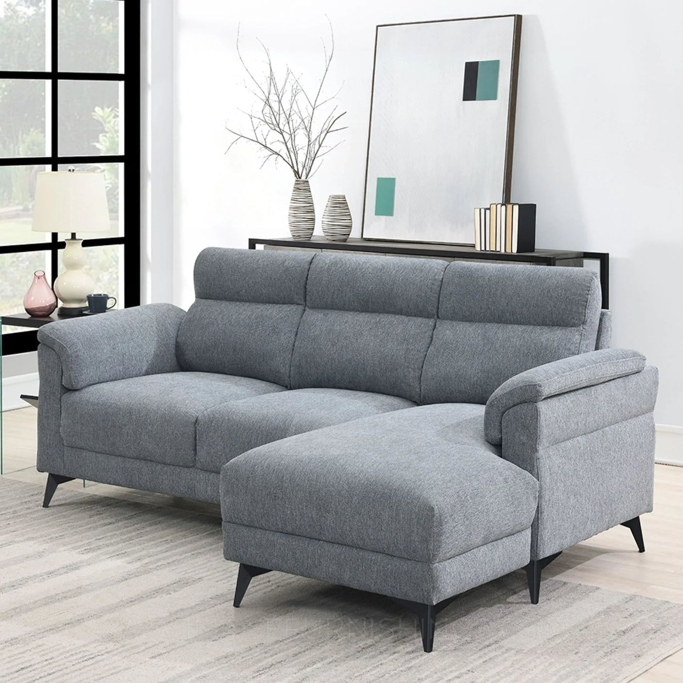 Grey fabric sectional sofa with chaise on right side in modern living room setting