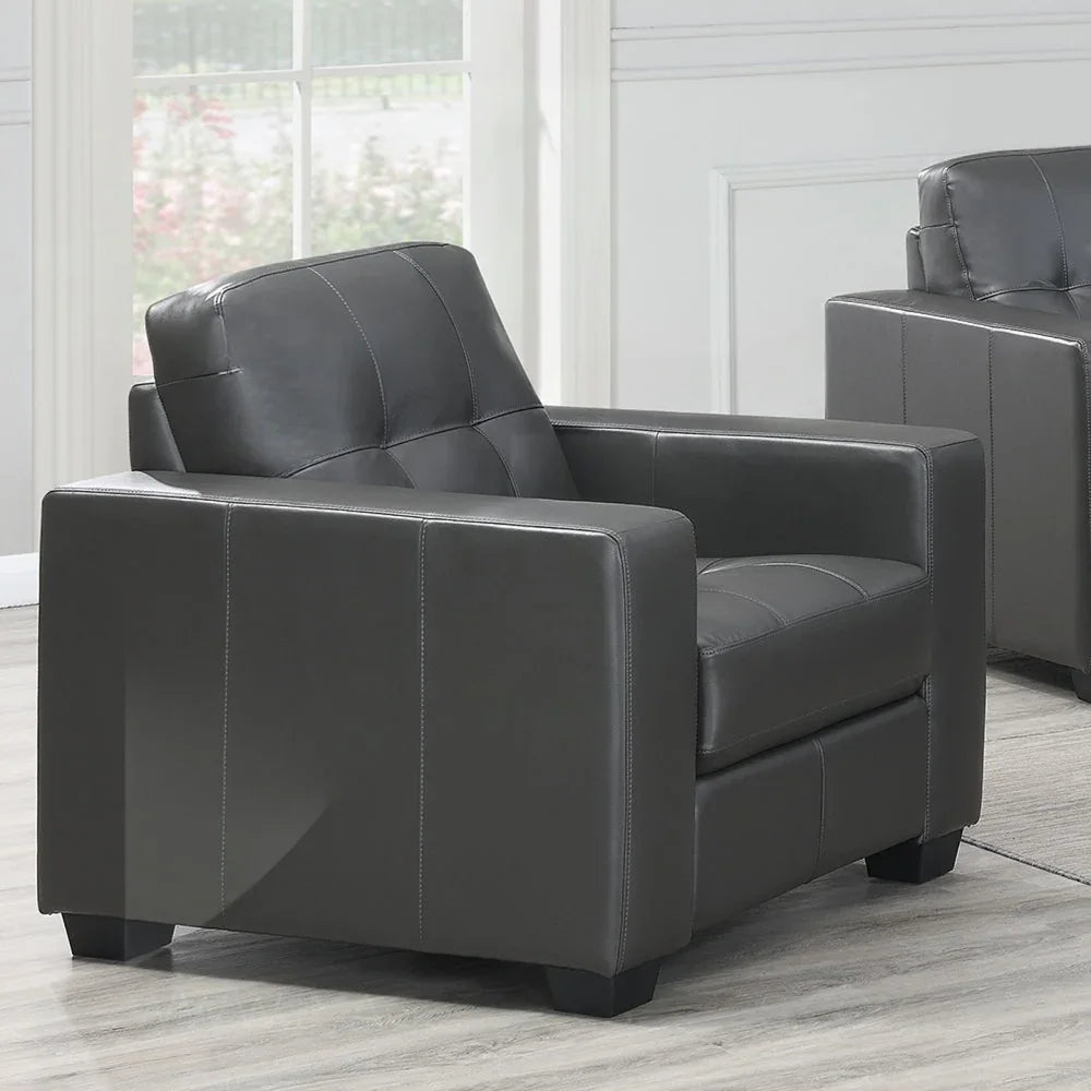 Dark grey leather armchair with square arms and tufted seat in modern living room