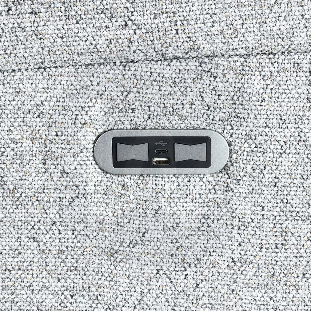 Close-up of USB charging port on silver fabric sofa