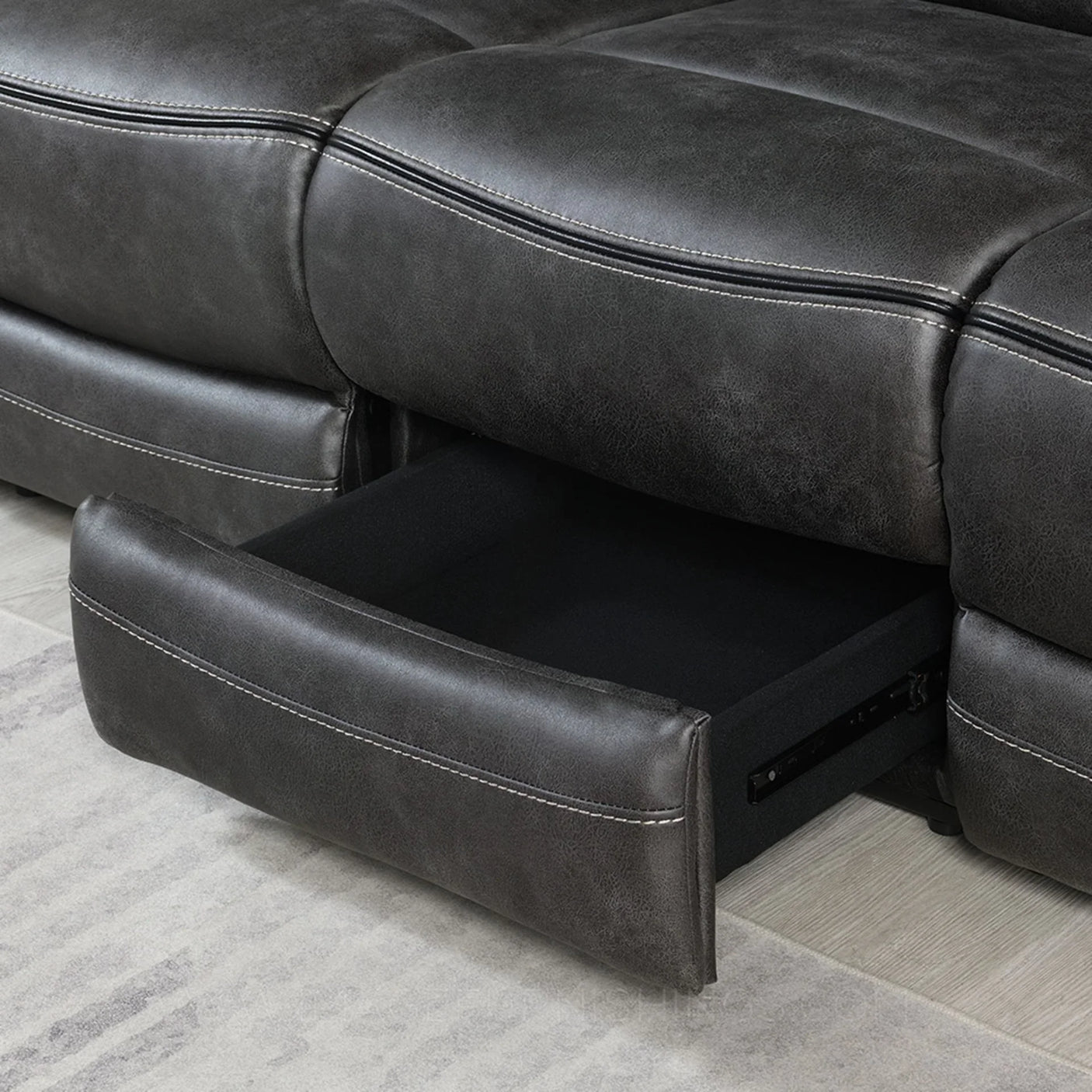 Grey recliner sofa with open storage drawer and contrast stitching detail on upholstery