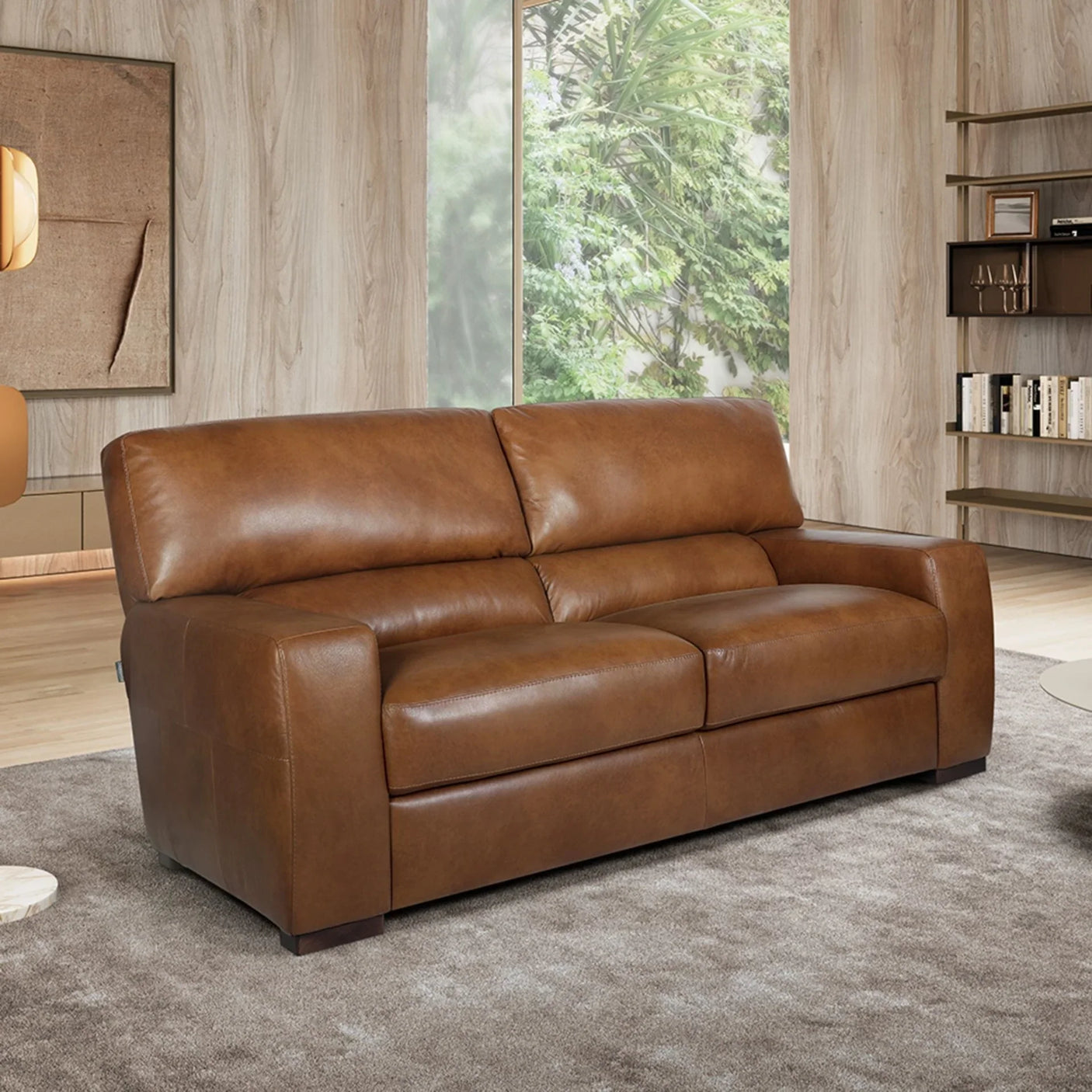 Tan Italian leather 2 seater sofa in modern living room with wood panel walls and shelving