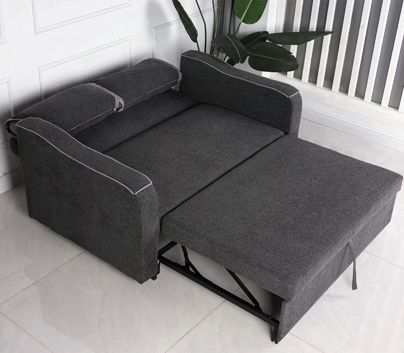 Charcoal fabric sofa bed extended with armrests and headrest in modern room