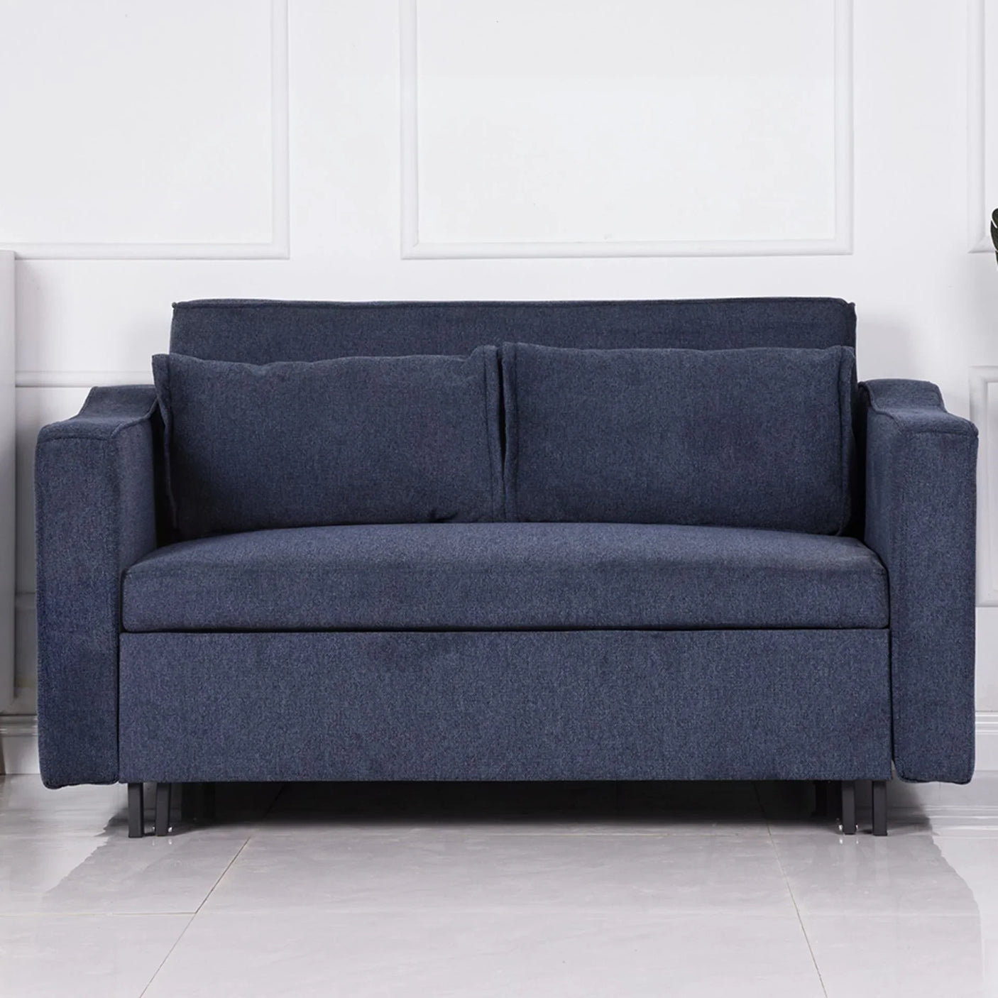 Denim blue sofa bed with two cushions and square arms on tiled floor
