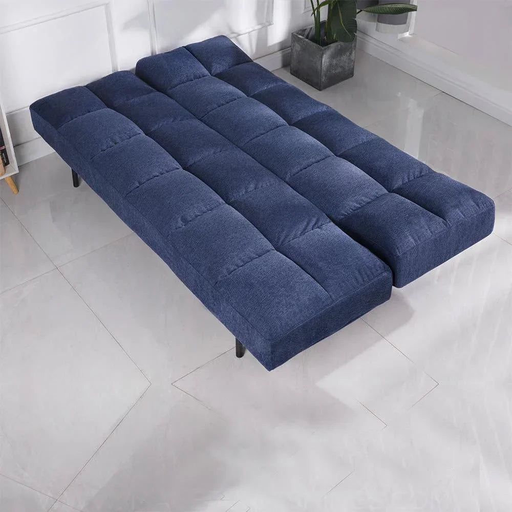 Denim blue sofa bed fully extended on tiled floor in bright modern room