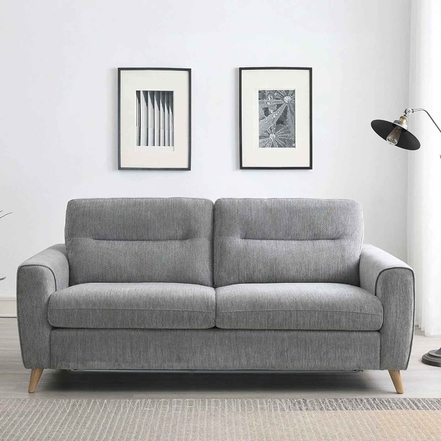 Grey fabric sofabed with wooden legs in modern living room setting